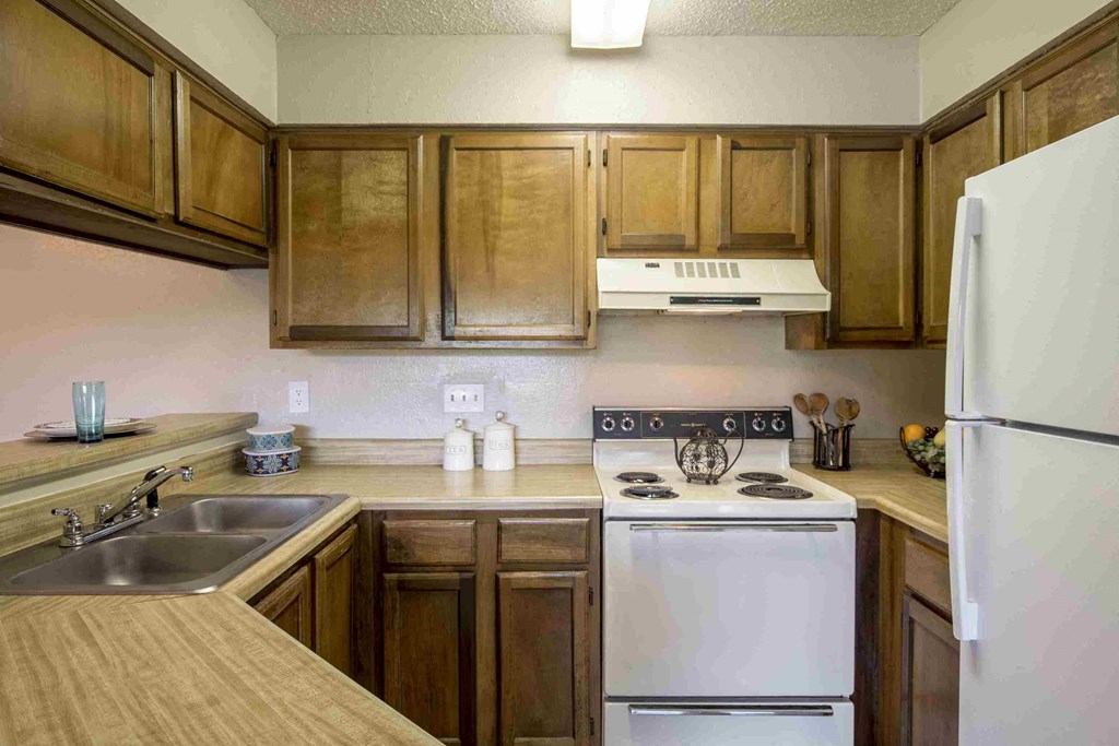 a kitchen with white appliances and wooden cabinets