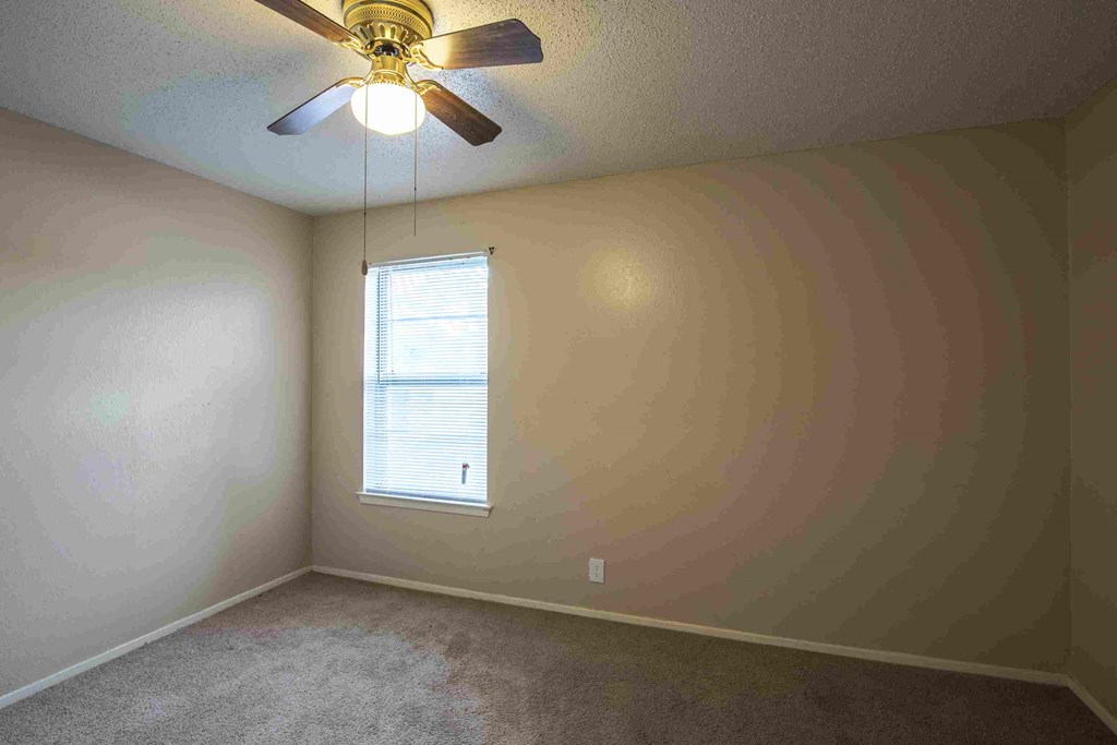 a bedroom with a ceiling fan and a window