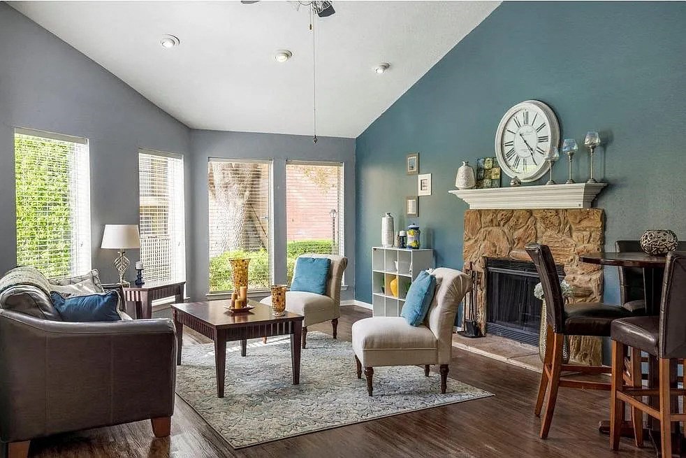 a living room with a fireplace and a clock on the wall