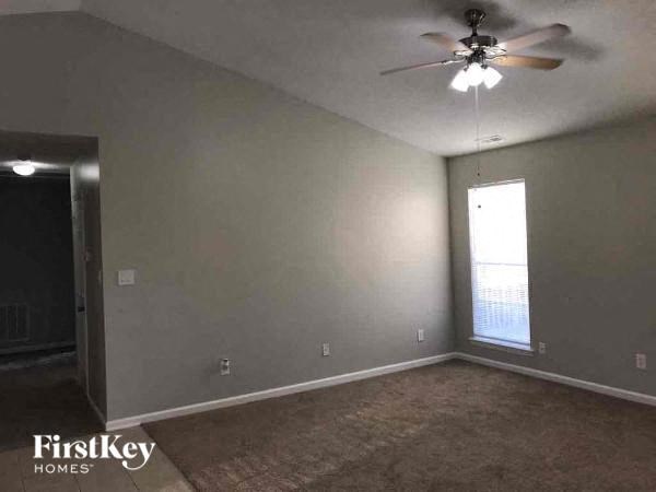 A room with a ceiling fan and a window.
