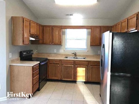 A kitchen with wooden cabinets and black appliances.