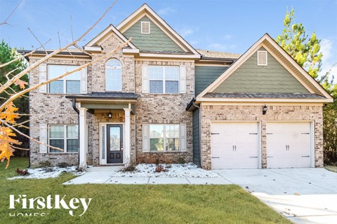a brick house with two white garage doors