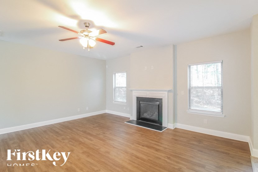 a living room with a fireplace and a ceiling fan