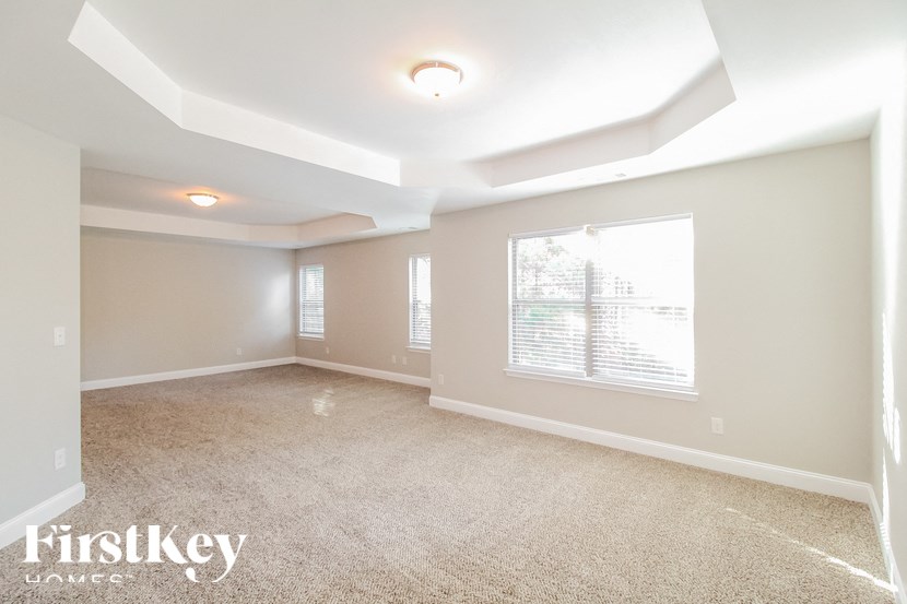 the living room of a new home with carpet and a large window