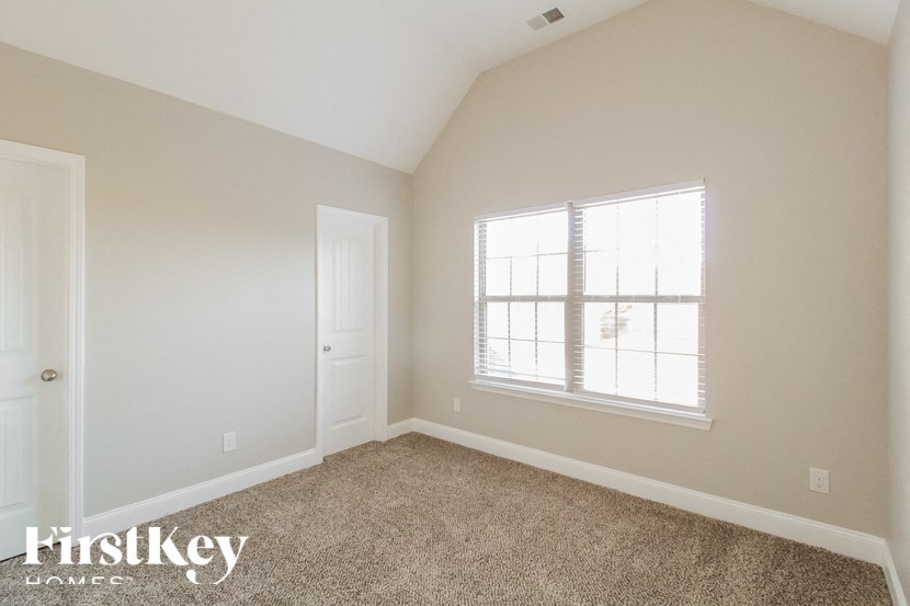 a bedroom with a carpeted floor and a window