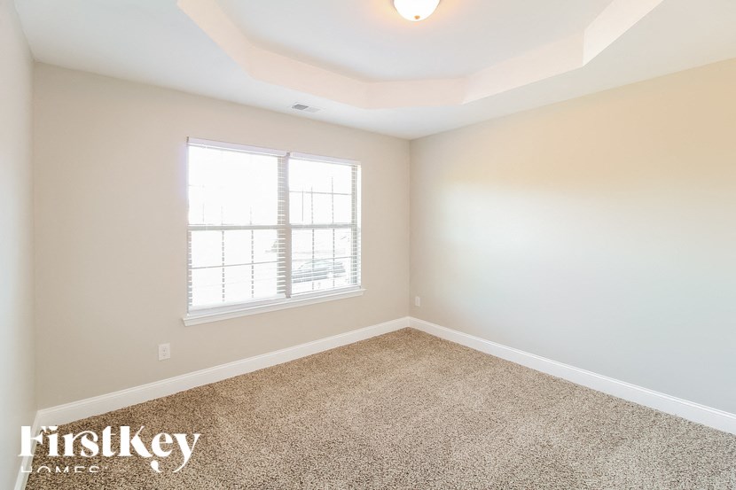 a empty room with carpet and a window