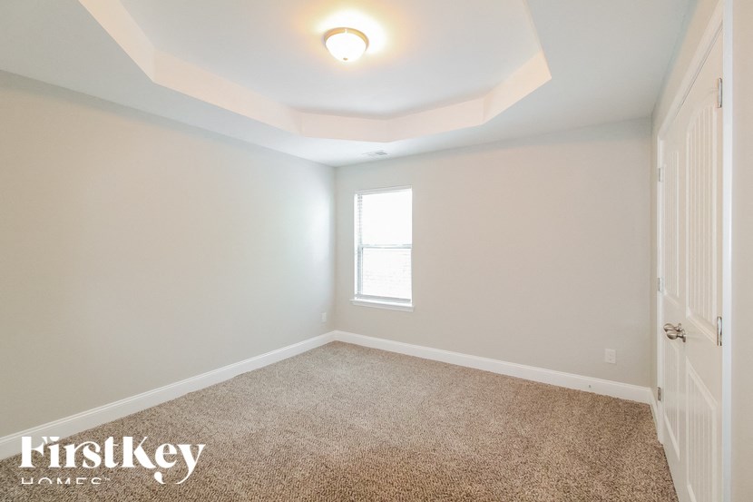 a bedroom with a carpeted floor and a window