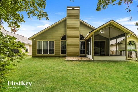 a yellow house with a porch and a grass yard