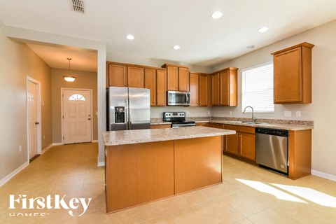 A kitchen with wooden cabinets and a refrigerator.