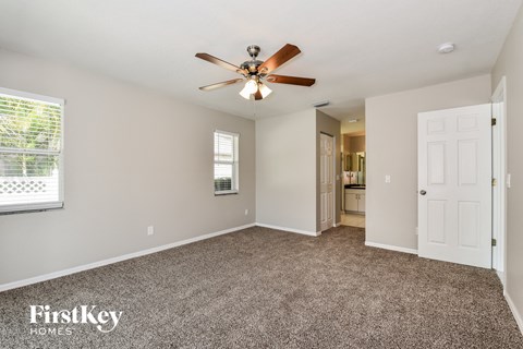 a living room with carpet and a ceiling fan