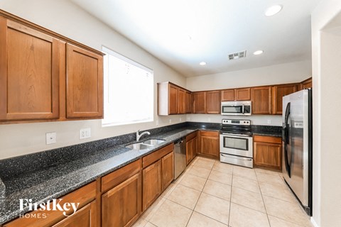 a large kitchen with wooden cabinets and stainless steel appliances