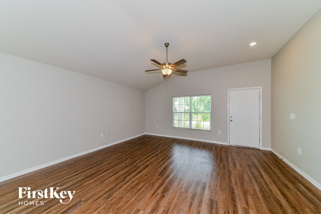 A room with wooden floors and a ceiling fan.