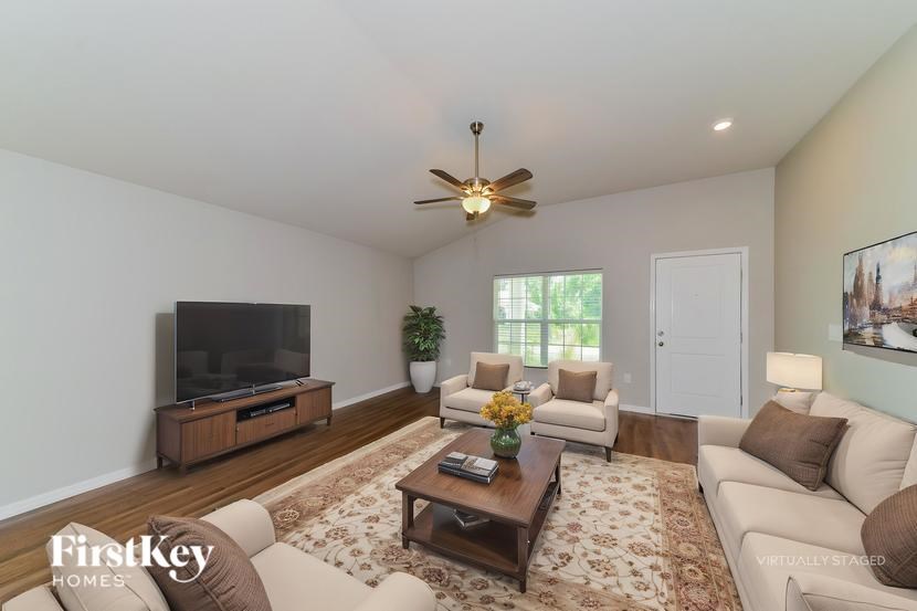 A living room with a television, couches, and a rug.