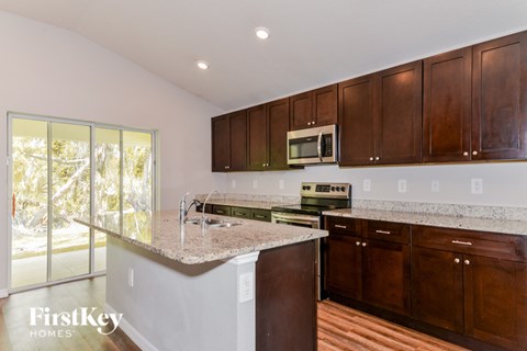 A kitchen with brown cabinets and a white counter top.