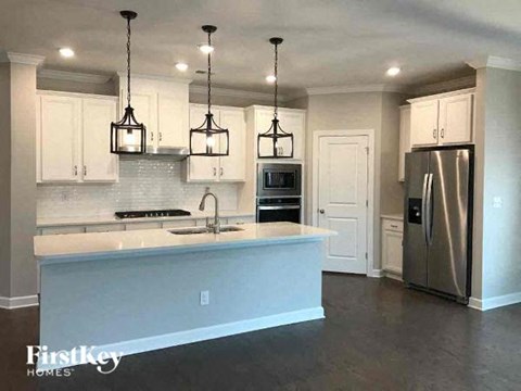 A kitchen with a stainless steel refrigerator and a white countertop.
