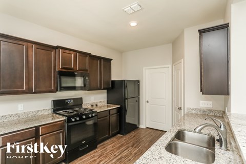 A kitchen with wooden cabinets and a stainless steel sink.