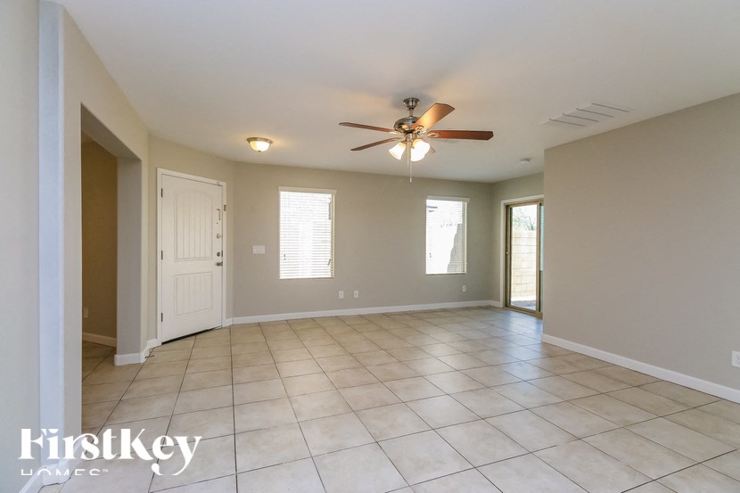 A spacious room with a ceiling fan and tiled flooring.