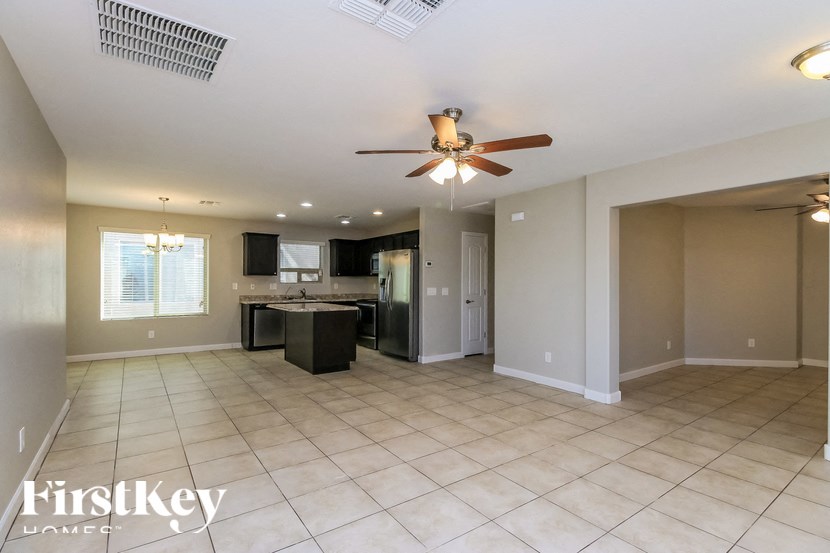 A spacious room with a ceiling fan and a kitchen area.