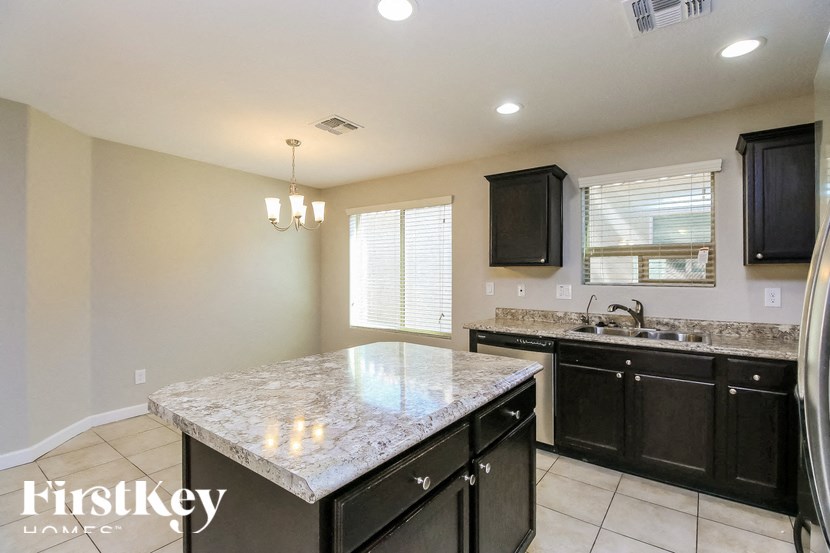 A kitchen with a granite countertop and black cabinets.