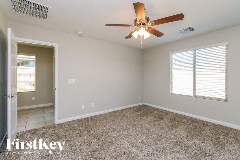 A room with a ceiling fan and carpeted floor.