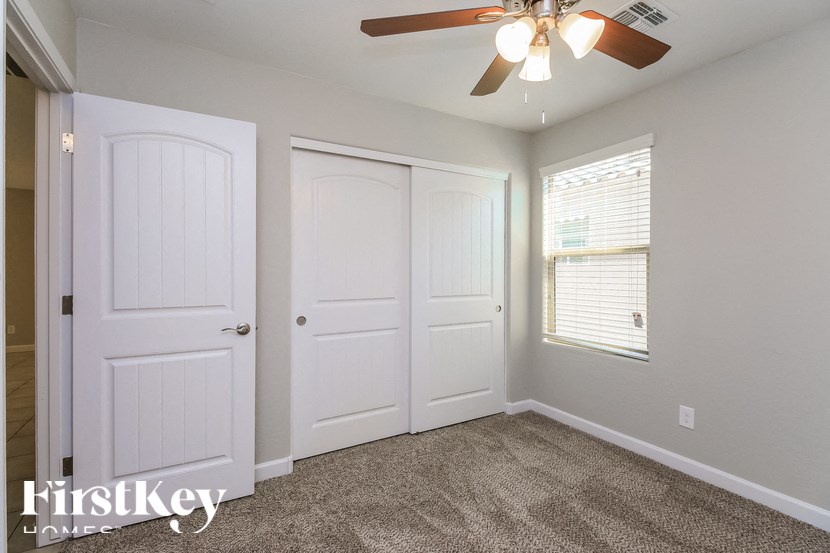A room with a ceiling fan and two doors.
