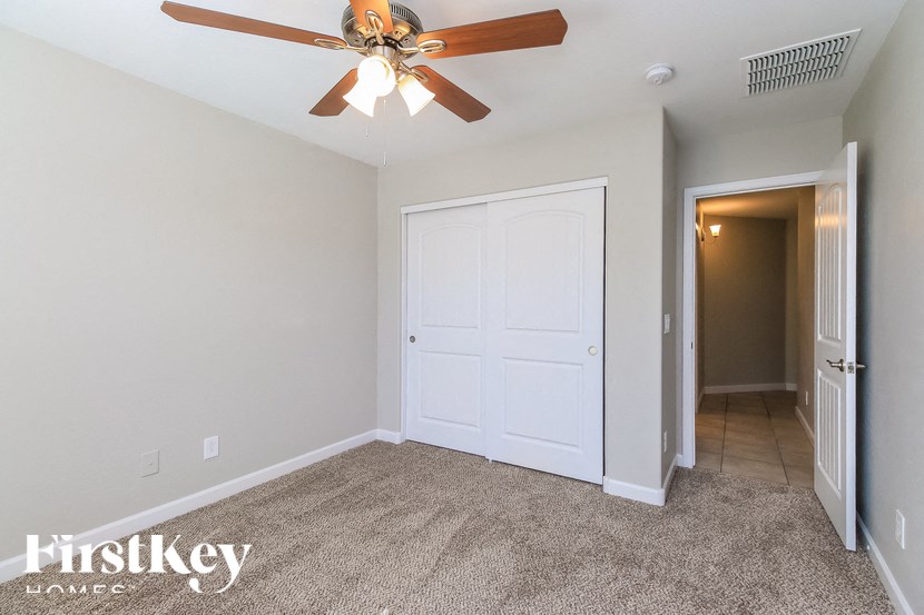 A room with a ceiling fan and a white door.