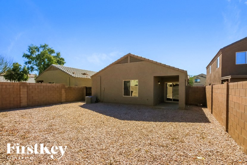 A house with a gravel driveway and a brick wall.