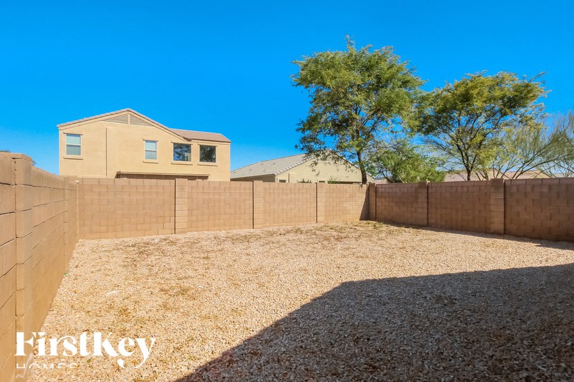 A house with a fence and a tree in the backyard.