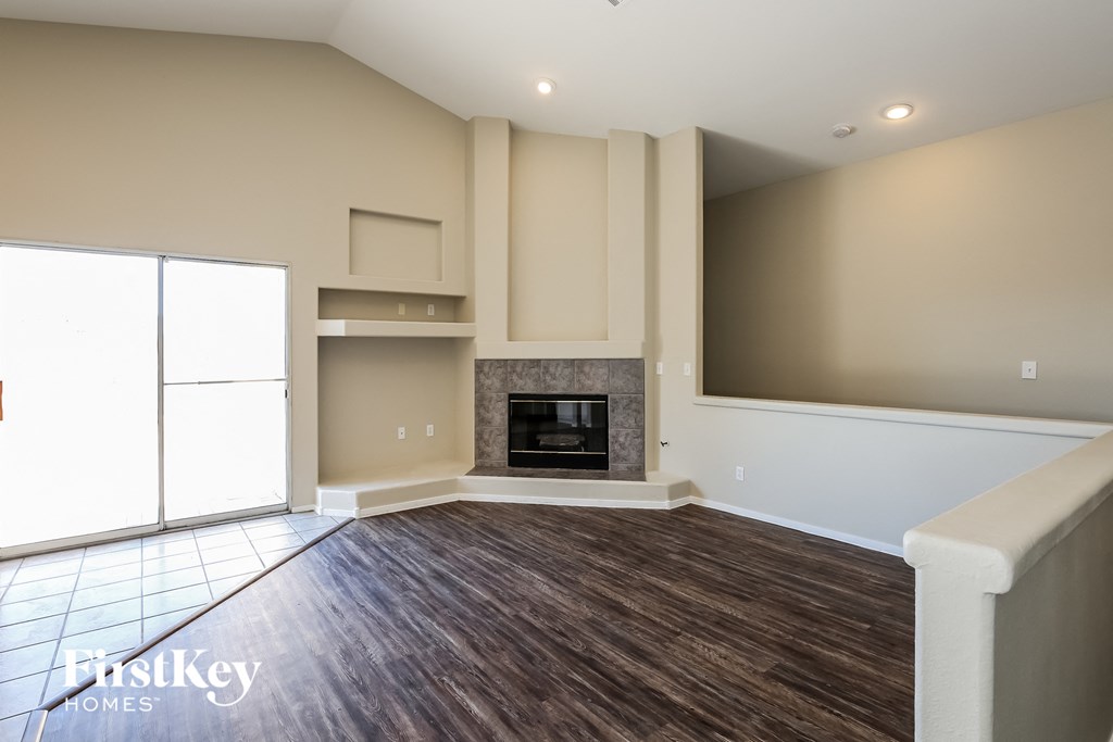 an empty living room with a fireplace and a window