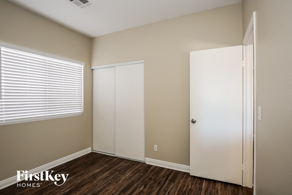 a bedroom with a closet and a window and a door