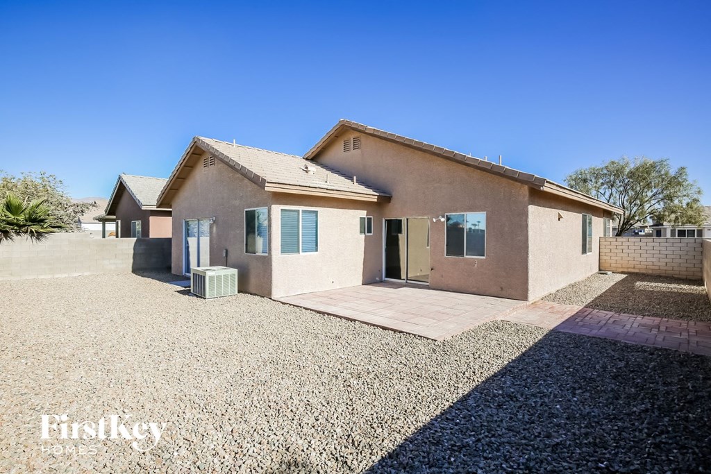 a small house with a gravel driveway and a porch