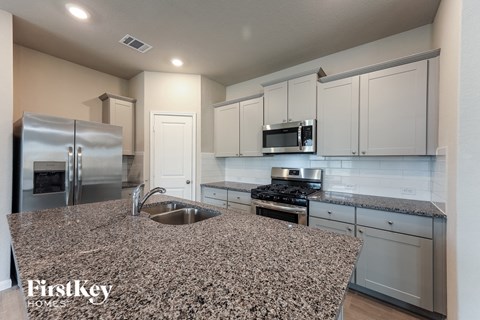 A kitchen with granite countertops and stainless steel appliances.