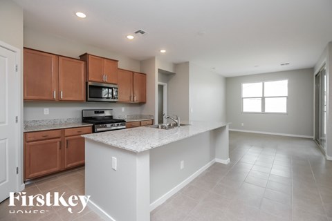A kitchen with wooden cabinets and a white island.