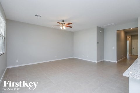 A spacious room with a ceiling fan and a tiled floor.
