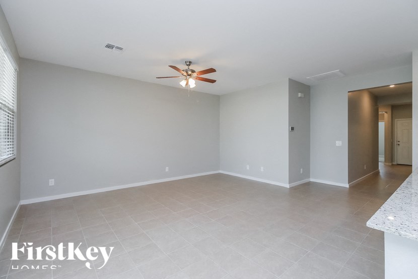 A spacious room with a ceiling fan and a tiled floor.