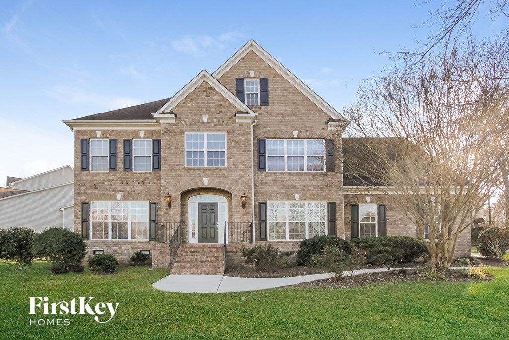 a home with a brick facade and a front yard