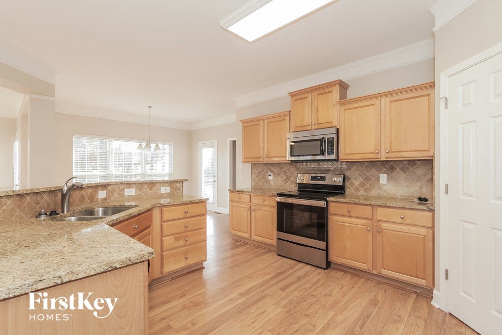an open kitchen with wooden cabinets and granite counter tops