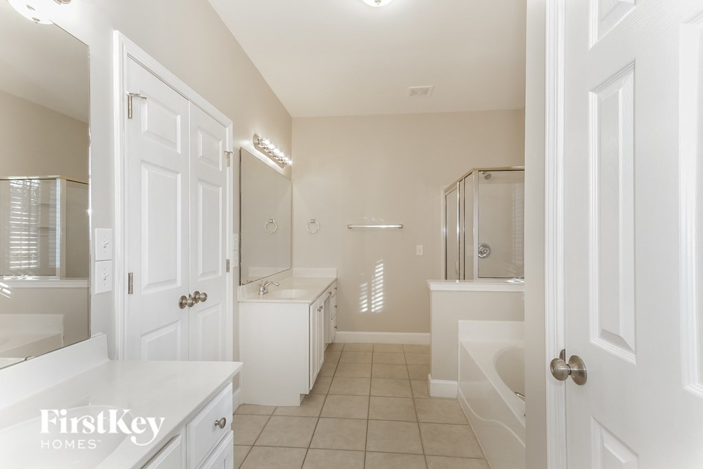 a bathroom with white cabinets and a sink and a mirror