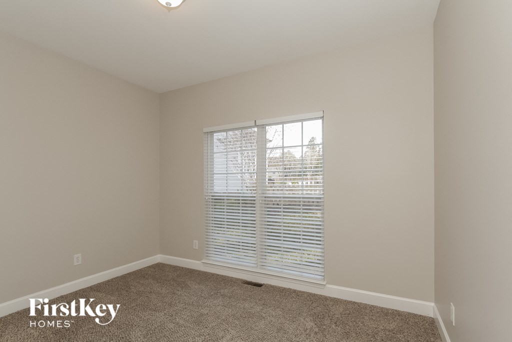 the living room of a home with a large window and carpet