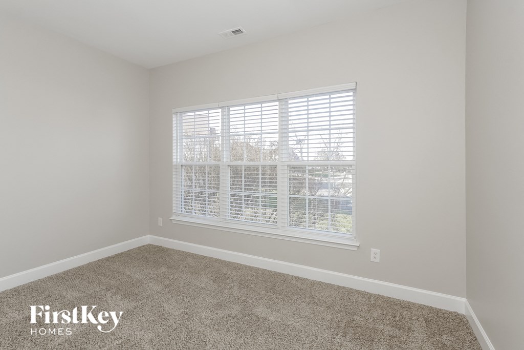 a empty room with a large window and carpet