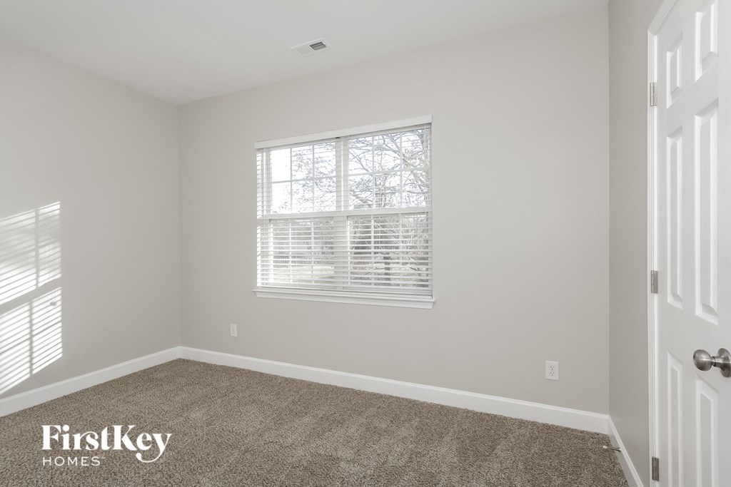 a bedroom with a carpeted floor and a window