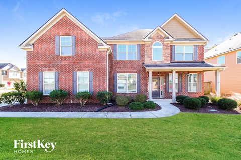a brick house with a front yard and grass