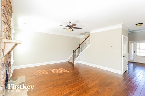 a living room with wood floors and a ceiling fan