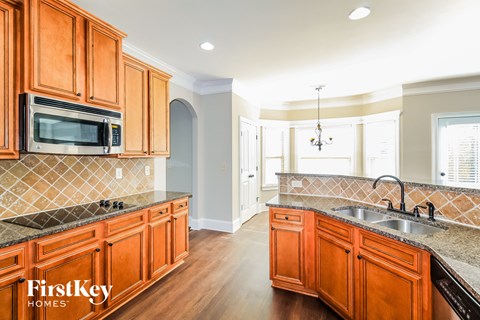 a kitchen with wood cabinets and granite counter tops and a sink