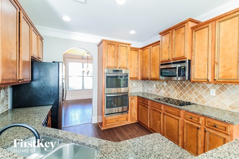 a kitchen with wooden cabinets and black appliances and granite counter tops