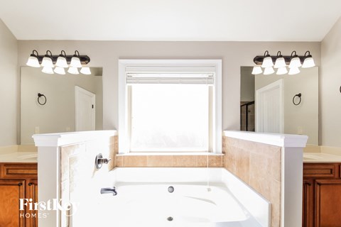 a bathroom with a large tub and a window