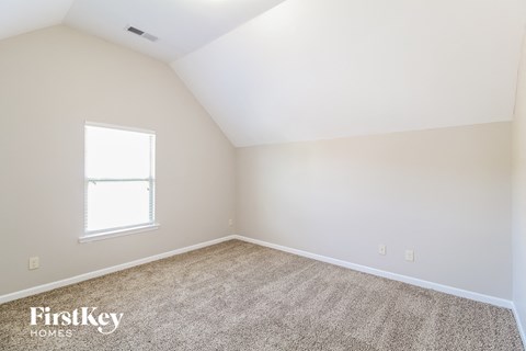 a bedroom with a carpeted floor and a window