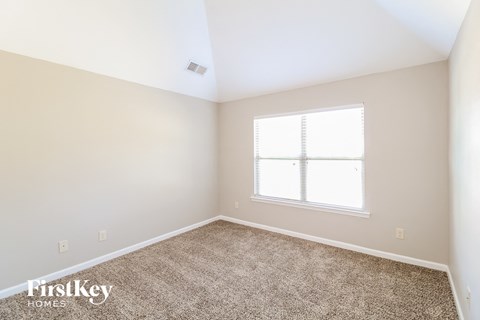a small room with a carpet and a window