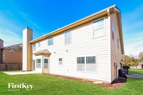 a white house with white siding and a yard with grass