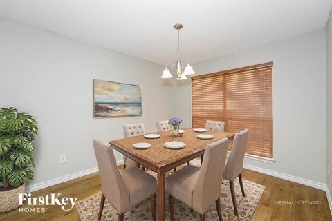 A dining room with a wooden table and chairs.
